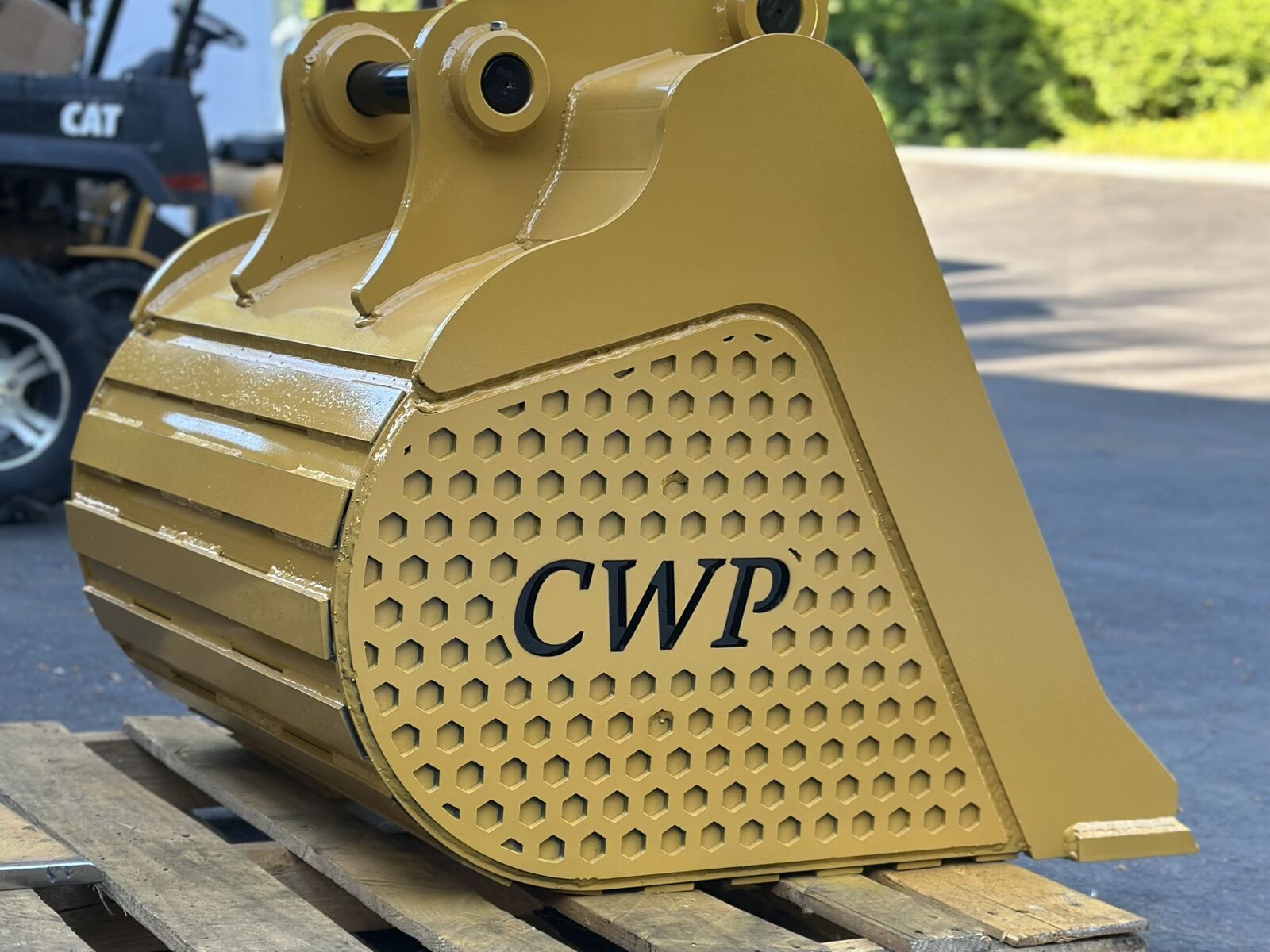 New severe-duty bucket in CAT yellow with a hex wear panel and CWP branding