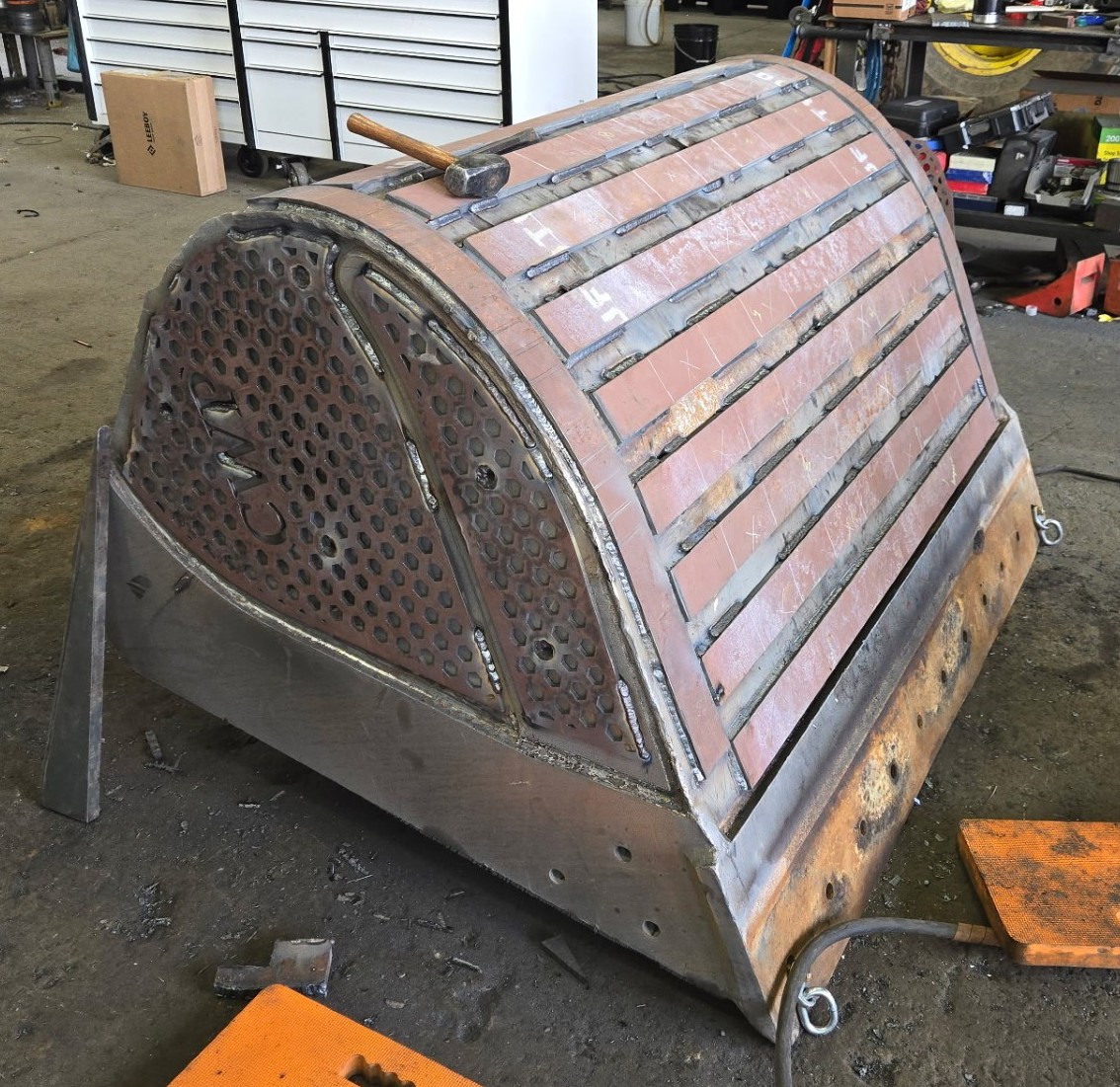Custom wear package installed on an excavator bucket, with wear bars and Power Plate armor welded in place