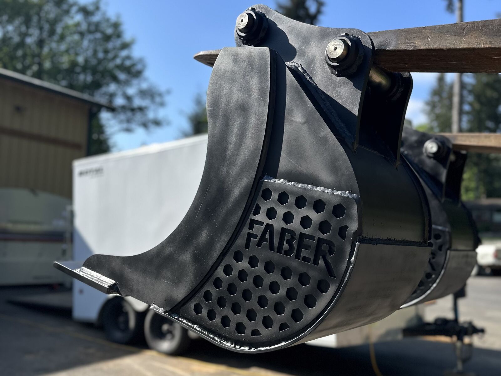 Hex-perforated wear panel and long-lip profile on a new bucket