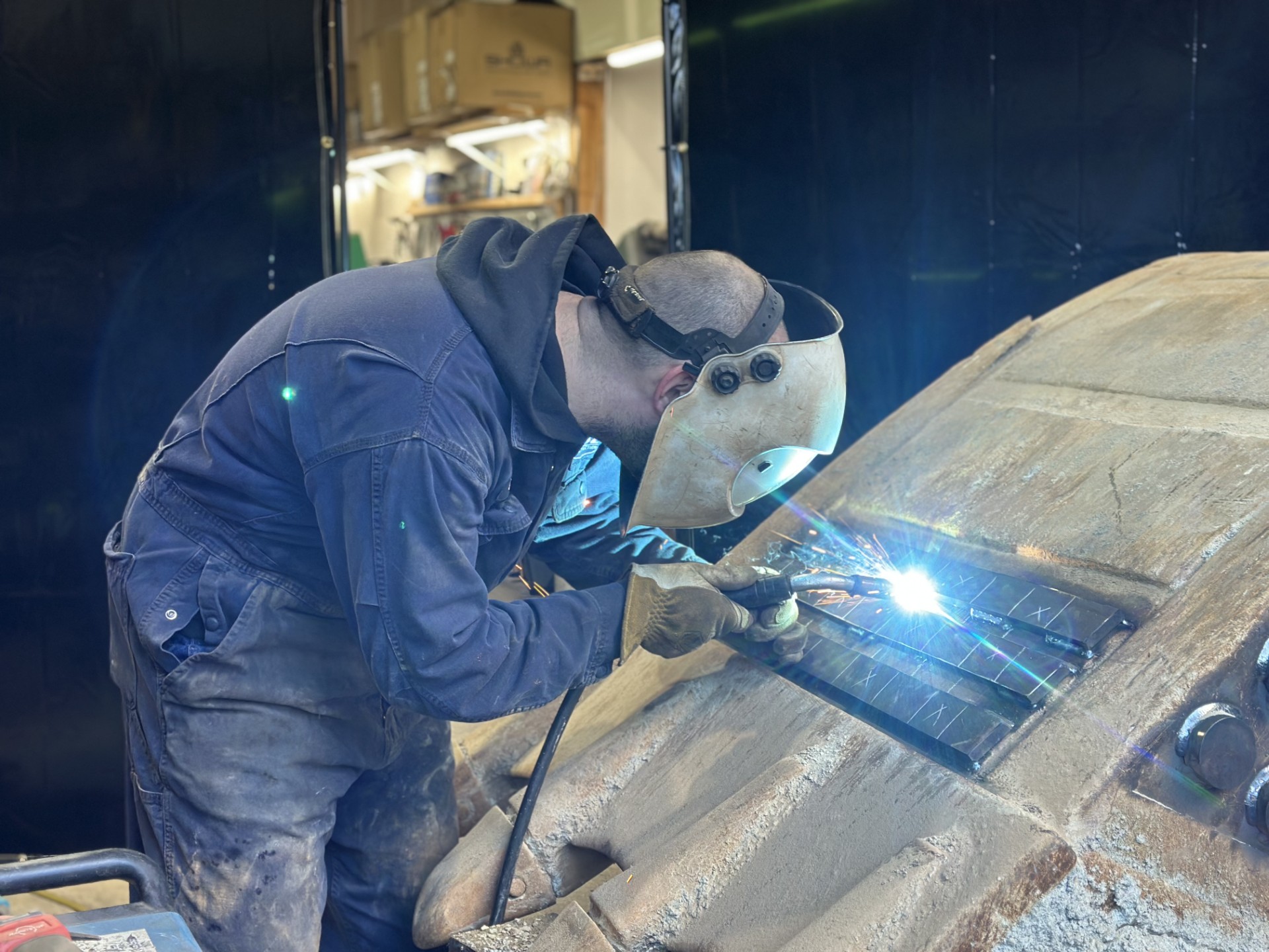 CWP fabricator welding new wear bars onto a fully armored excavator bucket